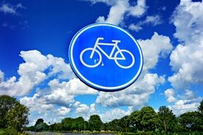 road sign with a bicycle on a background of blue sky with clouds