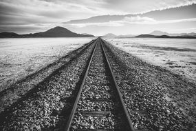 Black and white photo of the railroad tracks near the water