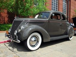 black vintage car on the road near the house