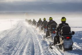 People ride a snowmobile