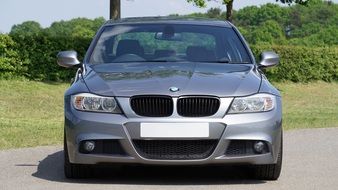 Shiny grey BMW car near the plants