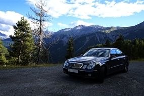 Mercedes, new black Car on road at mountain landscape