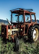 A hacked tractor stands on meadow