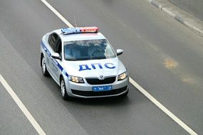 A police car is driving along the road