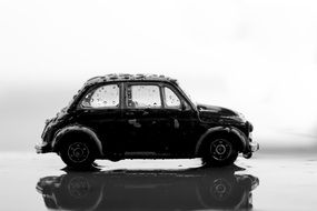 Black miniature car in drops of water