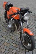 Close-up of the orange and black moped on the pavement