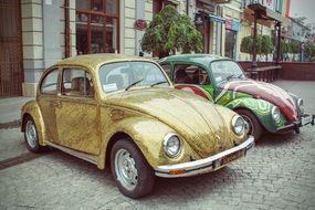 two vintage auto Volkswagen beetle on a city street