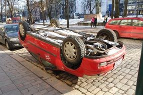 car on its roof on a city street