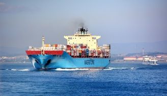 cargo ship with containers on the water on a sunny day