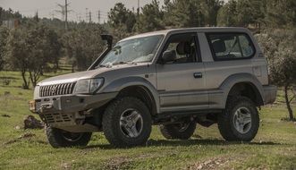 silver jeep on a green field
