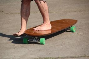 a man stands on a wooden skateboard