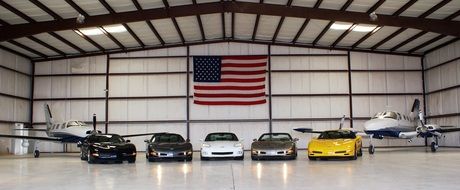 Cars and planes stand near the American flag