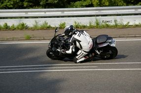 A motorcyclist rides along a curved road