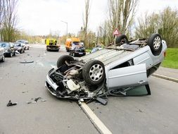 Inverted car with other cars on the road after an accident