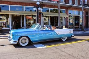 blue and white classic antique car on a road