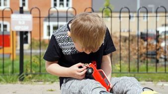boy with a miniature model of a mini cooper