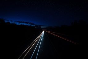 Headlights line on highway in the dark