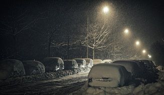 snow drifts on cars at night in Finland