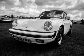 Black and white photo of Porsche on the grass on the landscape