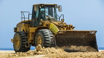 big yellow bulldozer in the sand