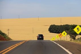 car rides on a highway to a wheat field in Parana, Brazil