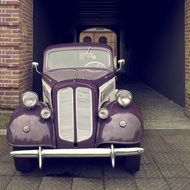 An old car is standing near the building