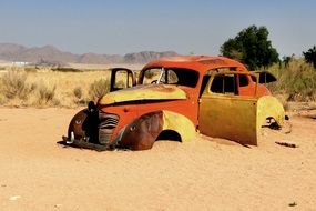 rusty wheelbarrow filled with sand