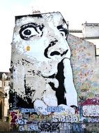 painted head of a man on the facade of a building in Paris