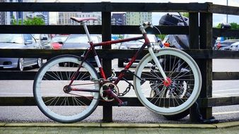 Bicycle with white wheels near the fence