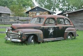 rusty Oldtimer Car on lawn at countryside