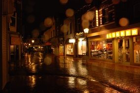 night photo of a shopping street in the rain