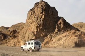 white jeep rides through the desert in Egypt