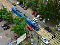 blue tram at a road intersection