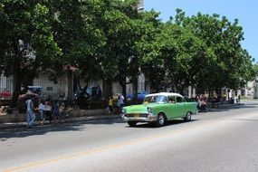 green oldtimer on a street in summer