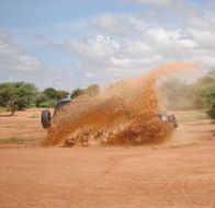 sand splashes from jeep races in Africa