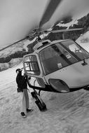 Black and white photo of a man near a helicopter