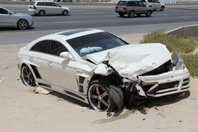 White wrecked car on the side of a road in an Arab country