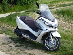 modern moped on green grass