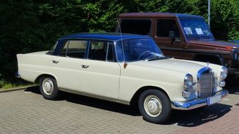 two vintage mercedes cars parked on the street