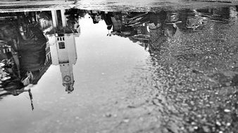 reflection of bell tower on the puddle