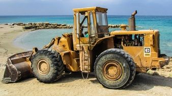 yellow bulldozer on the beach