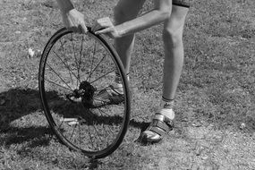 boy is repairing a bicycle wheel