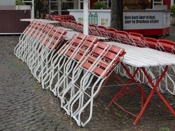 folded chairs of a street cafe in the rain