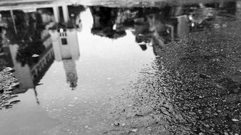 reflection of a city on puddle