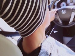 A young man is sitting behind the wheel of a car