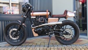 a bronze-colored motorcycle parked at the building