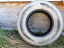 dusty rubber tire near a wooden wall