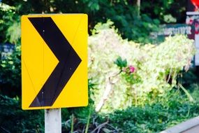 yellow road sign about turn warning