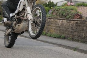 man riding Motorbike on rear wheel