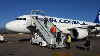 passengers go down the ramp from the plane at the airport